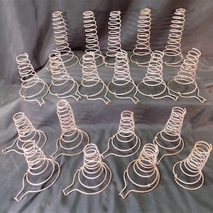 May include: A collection of 17 vintage metal springform cake pans. The pans are made of wire and have a conical shape. They are all in good condition and would be perfect for baking cakes, pies, or other desserts.