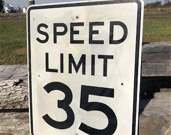 Peut inclure: Panneau de limitation de vitesse rectangulaire blanc avec texte noir "SPEED LIMIT 35". Le panneau affiche une limite de vitesse de 56 km/h. Bordure noire, monté sur une surface en bois.