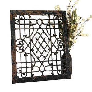 Puede incluir: Una rejilla de metal negro con un diseño decorativo. La rejilla tiene un aspecto rústico y envejecido y es perfecta para añadir un toque de encanto vintage a cualquier espacio.