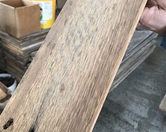 May include: A close-up of a weathered, light brown wood plank with a knot and grain pattern. The wood has a rustic, reclaimed look.