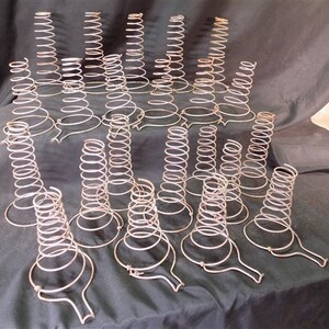 May include: A collection of vintage metal spring mattress supports. The supports are made of coiled wire and have a conical shape. They are designed to provide extra support for mattresses.