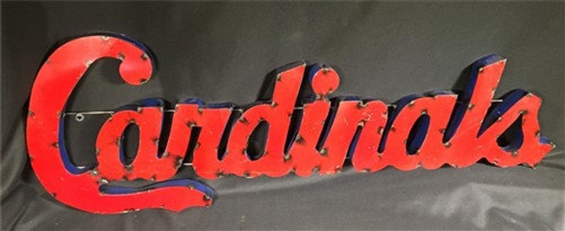 May include: A red and blue metal sign with the word "Cardinals" in a vintage style font.