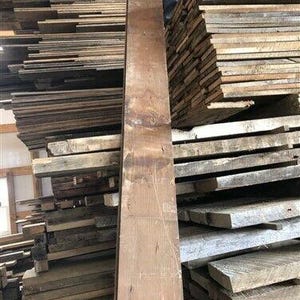 May include: A stack of reclaimed wood planks, some are rough and weathered, others are smooth and polished. The planks are various shades of brown and gray.