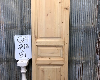 Puede incluir: Una puerta simple de madera clara con paneles en relieve. La puerta mide 62,2 cm de ancho y 205,7 cm de alto. La puerta está apoyada contra una pared de metal corrugado.