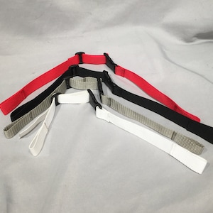 May include: Four adjustable straps with black buckles. The straps are red, black, white, and a light brown color.