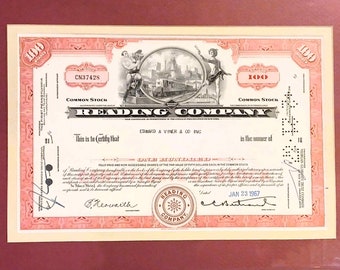 May include: A vintage stock certificate for Reading Company, a railroad company, dated January 23, 1967. The certificate is pink with black text and a black and white illustration of a train and city.