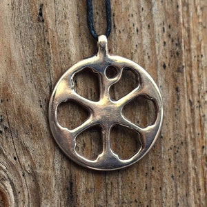 May include: A silver pendant necklace with a snowflake design. The pendant is hanging from a black cord.