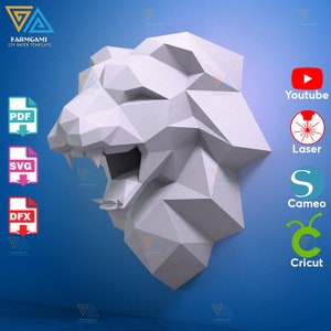 Könnte beinhalten: Ein weißes Papiermodell eines Löwenkopfes mit offenem Maul vor blauem Hintergrund. Das Bild enthält Logos für YouTube, Laserschneiden, Cameo und Cricut.