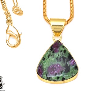 May include: A gold chain necklace with a teardrop-shaped pendant featuring a green and purple gemstone. The pendant has a gold setting.