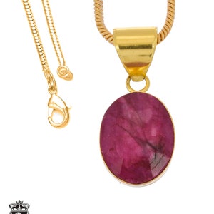 May include: A gold chain necklace with a pendant featuring a large oval-shaped ruby gemstone.
