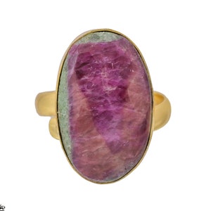 Puede incluir: Un anillo de oro con una gran piedra preciosa ovalada de color rosa y verde.