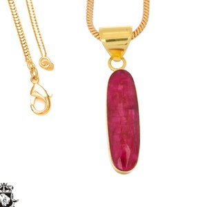 May include: A gold chain necklace with a pendant featuring a large, oval-shaped, deep red gemstone.