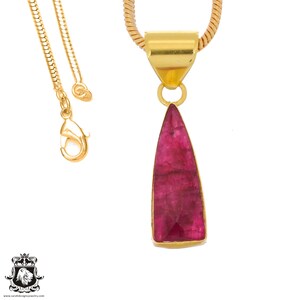Peut inclure: Un collier en chaîne dorée avec un pendentif en forme de larme de rubis facetté.