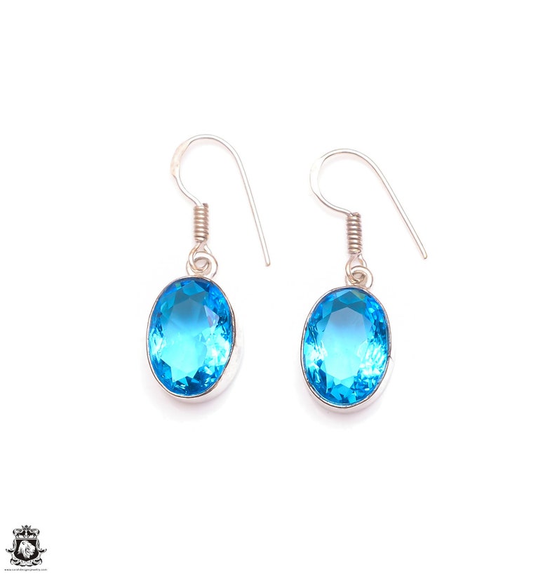 Puede incluir: Un par de pendientes de plata con piedras preciosas de topacio azul de forma ovalada.