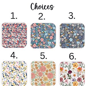Pu&ograve; includere: L'immagine presenta sei scelte di tessuto con motivi floreali. I motivi presentano una gamma di colori, tra cui rosa, blu, giallo e bianco, su uno sfondo bianco. Il testo "Fabric Choices" &egrave; scritto in alto.