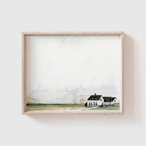 Puede incluir: Una pintura de acuarela de una casa de campo blanca con un techo negro en un campo. El cielo es de color azul claro con nubes blancas. La pintura está enmarcada en un marco de madera claro.