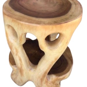 May include: A handcrafted wooden side table with a unique, organic design. The table features a round top with a dark brown center and a light brown outer ring. The base has open, heart-shaped cutouts. The table is approximately 18 inches tall.