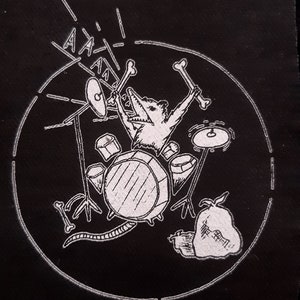 Op de afbeelding: Een zwart-witte illustratie van een rat die drums speelt. De rat draagt een hoed en houdt drumsticks vast. De rat is omringd door drums en bekkens. De illustratie is op een zwarte achtergrond.