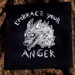 Könnte beinhalten: Schwarzweiß-Illustration eines Wolfes mit drei Augen und offenem Maul, mit dem Text "Embrace your anger" über dem Wolf.