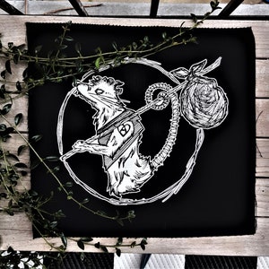 May include: Black and white illustration of a rat carrying a sack on its back. The rat is depicted in a circle with a stylized design. The image is on a black background.