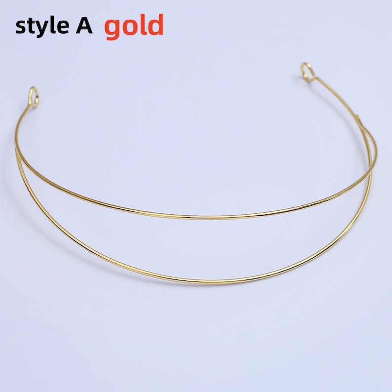 May include: A gold-colored necklace with a double-layered design. The necklace is made of thin, curved metal and features the text "style A gold" in the upper left corner. The necklace is displayed on a white background.