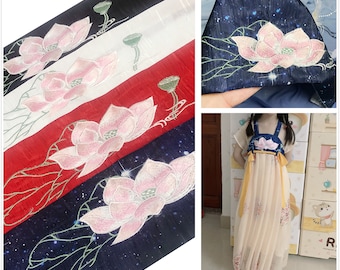May include: Four different fabric swatches with embroidered lotus flowers. The fabrics are white, red, navy blue with white stars, and navy blue with silver stars. The lotus flowers are pink with white accents.