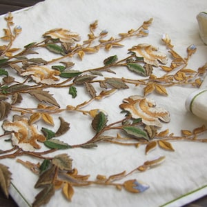 May include: A collection of embroidered floral appliques featuring delicate white roses with brown and green stems and leaves.