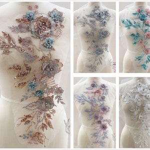 Könnte beinhalten: Sortiment an floralen Applikationen mit Pailletten und Perlen. Die Applikationen sind in verschiedenen Farben, darunter Rosa, Blau und Weiß. Sie sind perfekt, um jedem Kleidungsstück einen Hauch von Eleganz zu verleihen.