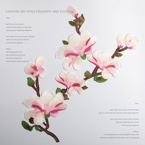 May include: Embroidered patch featuring a branch of white and pink magnolia flowers with green leaves. The patch is perfect for adding a touch of elegance to clothing, bags, or home decor.