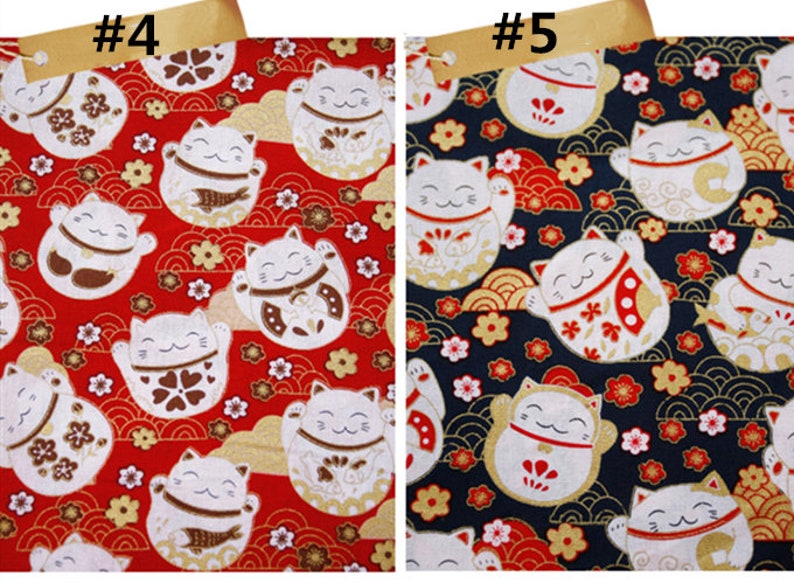 Puede incluir: Tela con un patr&oacute;n repetido de gatos de la suerte Maneki-Neko blancos con las patas levantadas, sobre fondos rojos y azul marino. Los gatos tienen detalles dorados, marrones y rojos, con motivos florales y de olas.