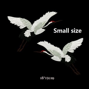 May include: Two white embroidered crane patches with black and red details. The patches are 18 by 13 centimeters and are labeled "Small size".