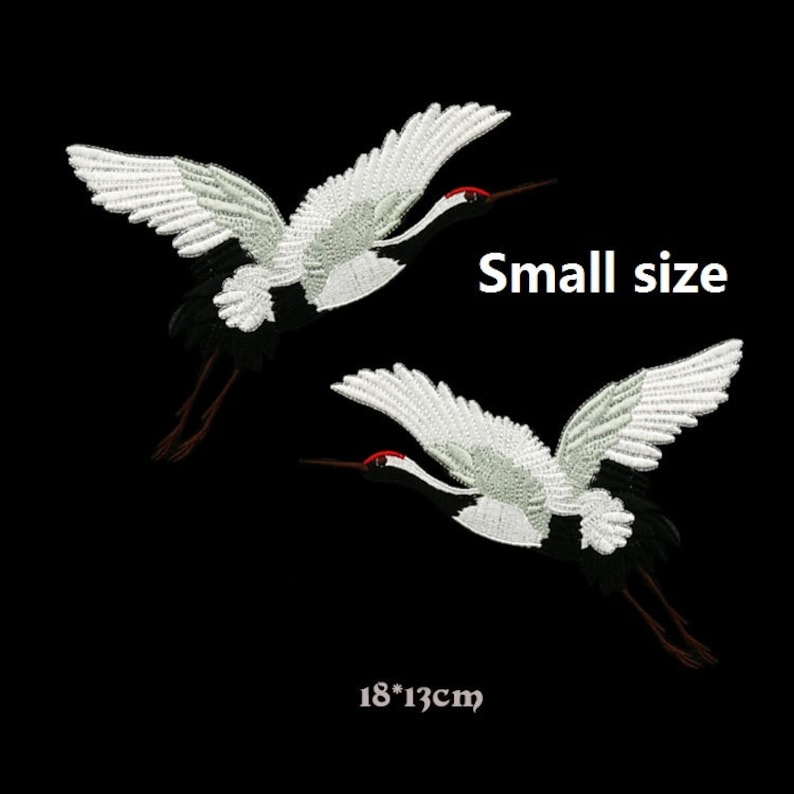May include: Two white embroidered crane patches with black and red details. The patches are 18 by 13 centimeters and are labeled "Small size".
