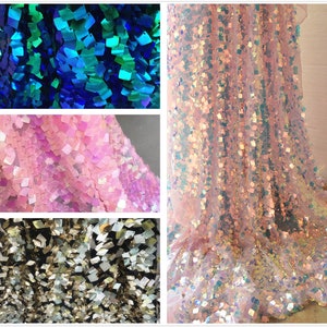 May include: Close-up shots of shimmering fabric in various colors. The fabric is covered in square sequins, creating a textured, reflective surface. Colors include shades of blue, pink, and silver, with a light, airy quality. Ideal for apparel or decorative projects.