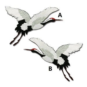 May include: Two white and black embroidered iron-on patches of Japanese cranes in flight. The patches are labeled A and B.