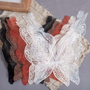 Peut inclure: Cinq appliques en dentelle en forme de papillon superposées en noir, marron, rouge, blanc et beige. Les appliques sont délicates et complexes, avec un motif floral.