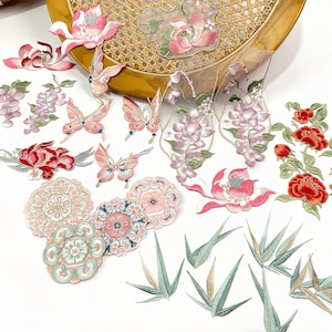 Peut inclure: Collection de patchs brodés avec des motifs floraux et papillons. Les patchs présentent des fleurs roses, rouges et vertes, ainsi que de délicats papillons roses. Des patchs circulaires à motifs et des accents de feuilles vertes sont également présents.