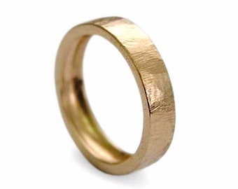 May include: A simple gold band ring with a hammered finish.