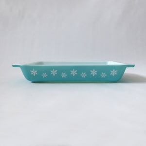 May include: A light blue baking dish with a white snowflake pattern around the rim.