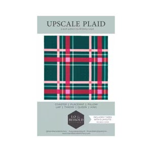 May include: A quilt pattern titled Upscale Plaid by Brittany Lloyd. The cover features a dark green, red, and light pink plaid design. Text includes Coaster, Placemat, Pillow, Lap, Throw, Queen, King, Lo & Behold Stitchery, and Includes 7 sizes with 5 layouts.
