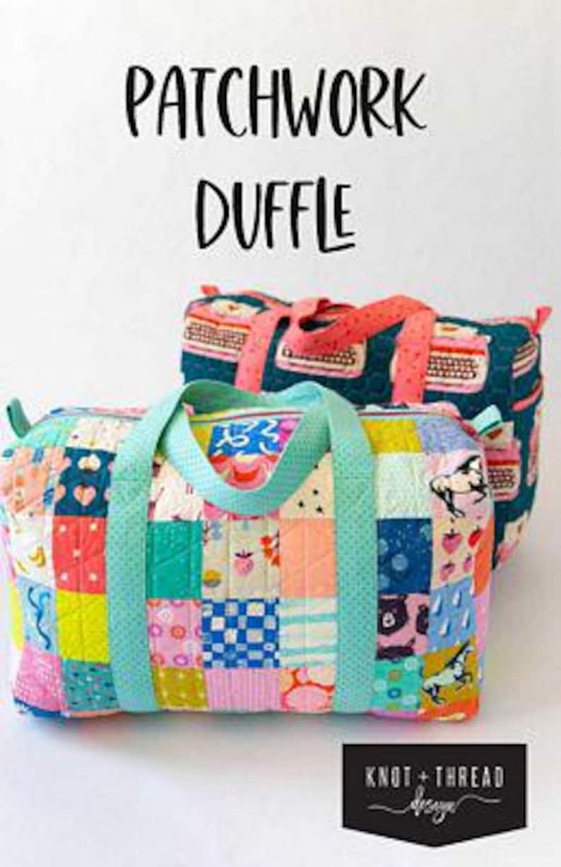 May include: Two patchwork duffle bags with colorful, patterned fabric. The front bag has a patchwork design with squares of various colors and patterns, including strawberries, bears, and horses. The handles are a light teal color. The text "PATCHWORK DUFFLE" is at the top.