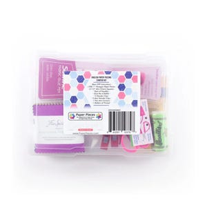 May include: A clear plastic storage case containing an English Paper Piecing Starter Kit. The label lists contents including 100 one-inch hexagon paper pieces, 2.5-inch charm squares, needles, a glue pen with refills, clips, scissors, and thread.