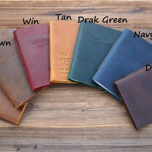 May include: Seven leather-bound journals in different colors, including brown, tan, dark brown, navy, green, and burgundy. Each journal has the word "Officiant" embossed on the cover.
