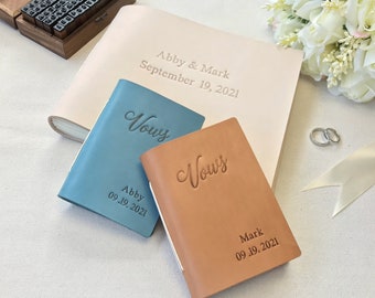 May include: Two leather-bound vow books with the word "Vows" embossed on the front. The blue book is for Abby and the brown book is for Mark. Both books have the date September 19, 2021, embossed on the front.