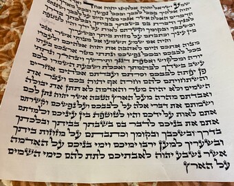 May include: A close-up of a page of text written in Hebrew. The text is printed in black ink on white paper. The paper is lying on a brown and white patterned surface.