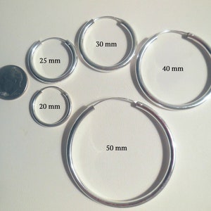 Può includere: Cinque orecchini a cerchio d'argento di diverse dimensioni. I cerchi hanno un diametro di 20 mm, 25 mm, 30 mm, 40 mm e 50 mm.