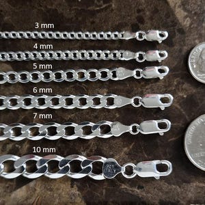 Peut inclure: Chaînes en argent de type gourmette de 3 mm, 4 mm, 5 mm, 6 mm, 7 mm et 10 mm de large. Les chaînes sont présentées à côté d'une pièce de 10 cents et d'un quart de dollar américain pour comparaison. Chaque chaîne a un fermoir mousqueton.