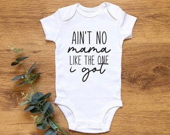 Może przedstawiać: Biały śpioszek dla niemowlęcia z czarnym napisem "Ain't no mama like the one I got".