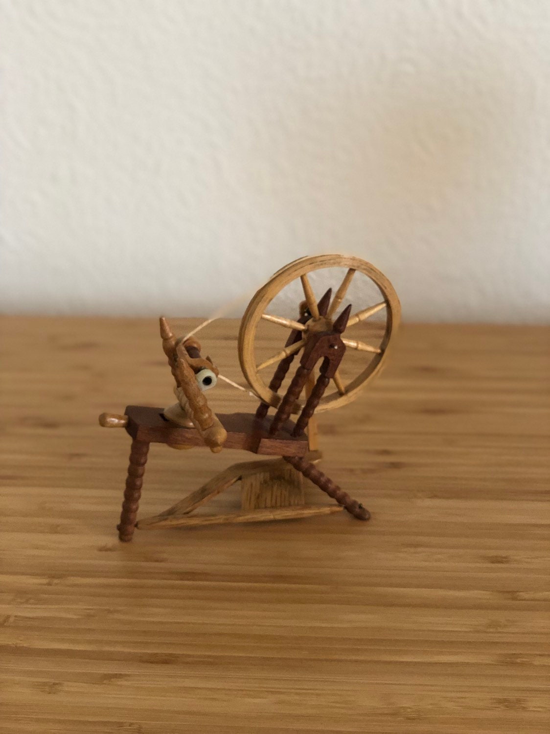 Miniature hand carved wooden spinning wheel with working wheel and pedal