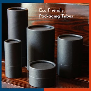 May include: A collection of four matte black cylindrical cardboard packaging tubes of varying heights and widths, featuring the white text Eco Friendly Packaging Tubes printed clearly in the upper right section of the image.