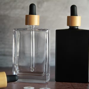 Botella rectangular de vidrio transparente: envase cosmético de 3,4 oz